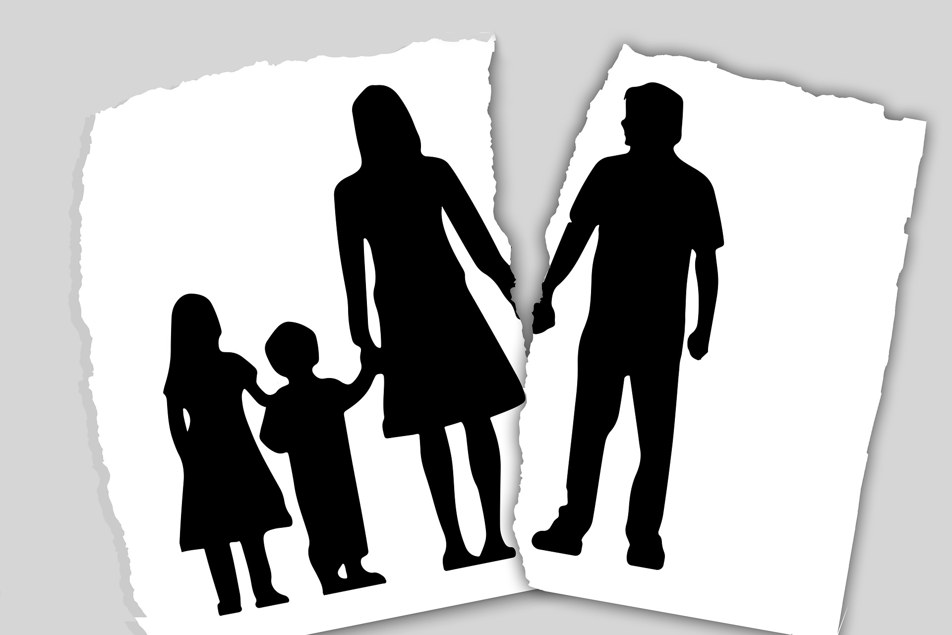 Silhouette of a family divided onto two torn pieces of paper, representing child custody issues in New Jersey with a mother and child on one side, and a father and child on the other.
