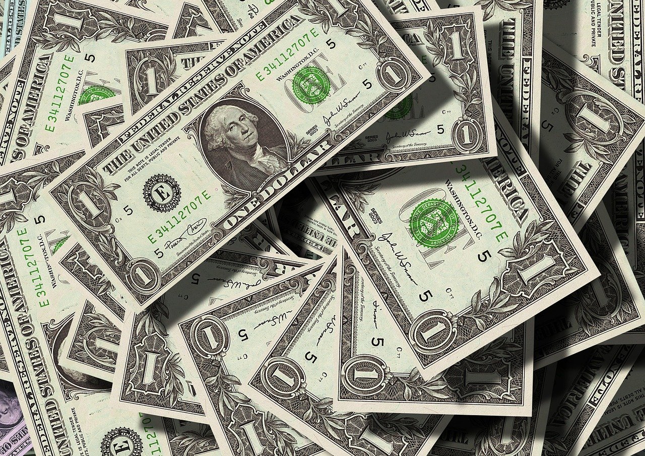 A close-up image of numerous scattered US one-dollar bills, symbolizing the financial disputes often seen in divorce cases, with a focus on their intricate designs and serial numbers.