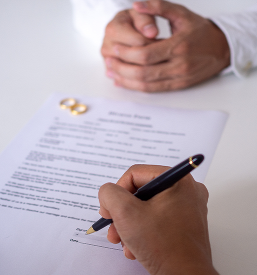 Hands of wife and husband signing decree of divorce dissolution or canceling marriage or legal separation