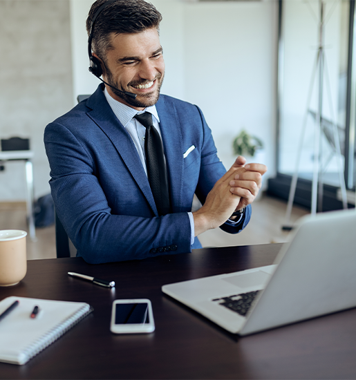 Happy businessman having conference call over laptop in the office