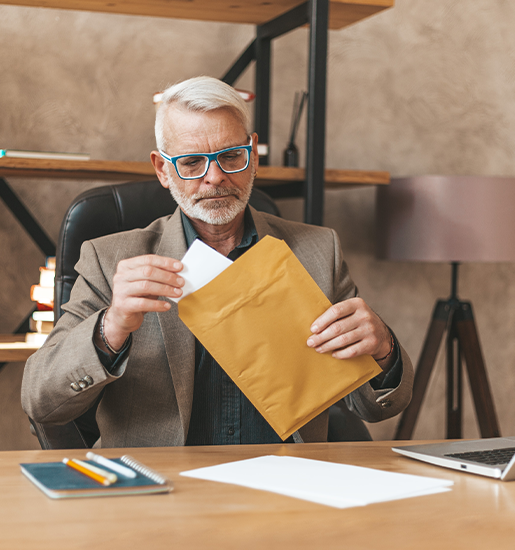 The courts decision A mature man opens an envelope with documents at the table