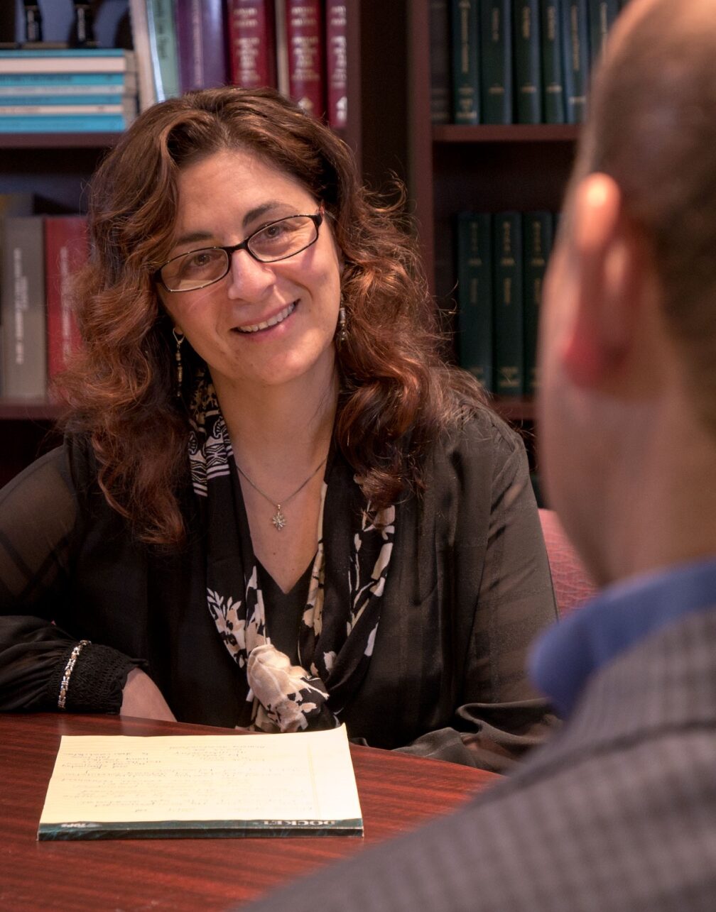 Photograph of Sarina Gianna, Esq., New Jersey divorce lawyer in her office with a client.