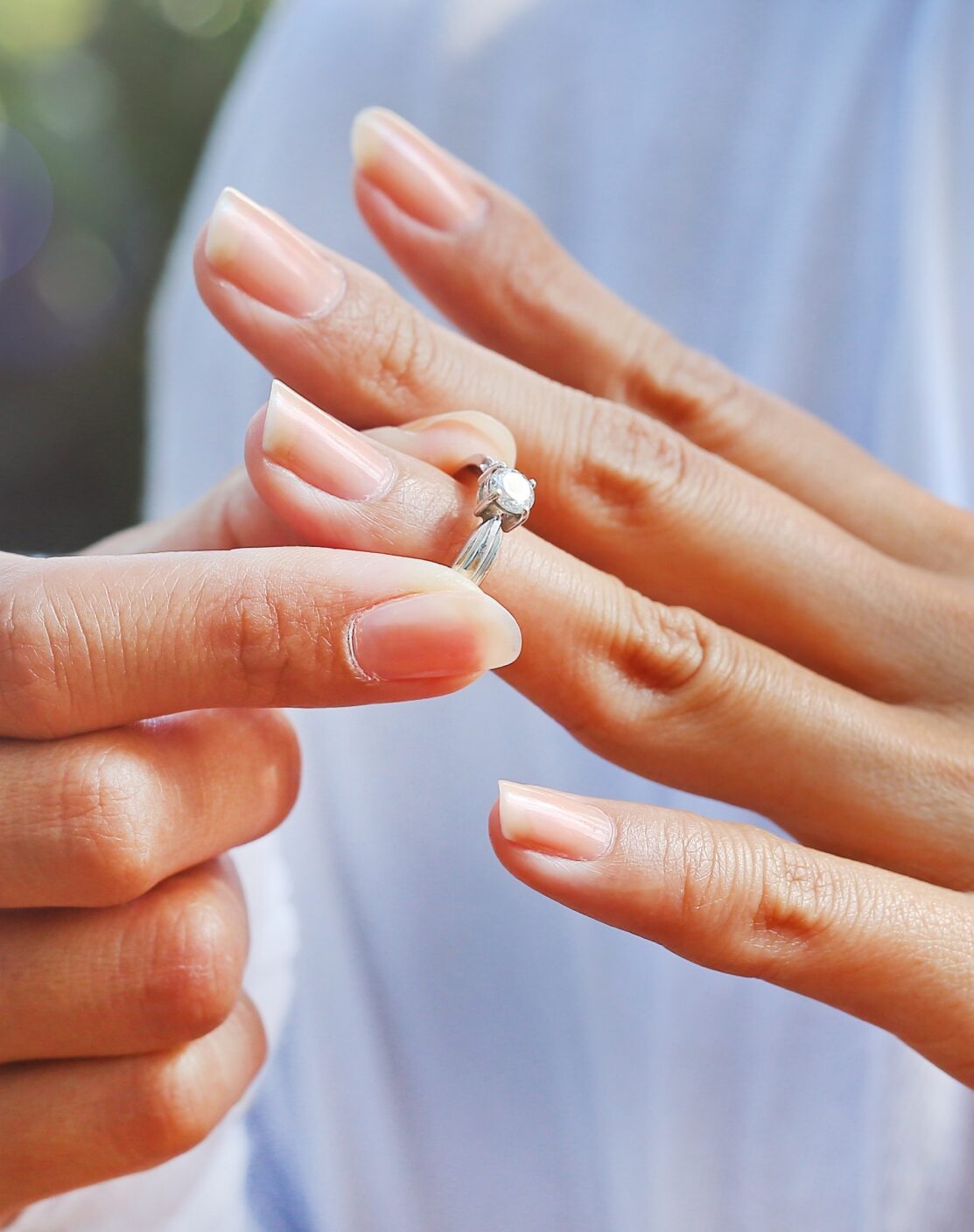 Woman removing wedding ring from her finger.