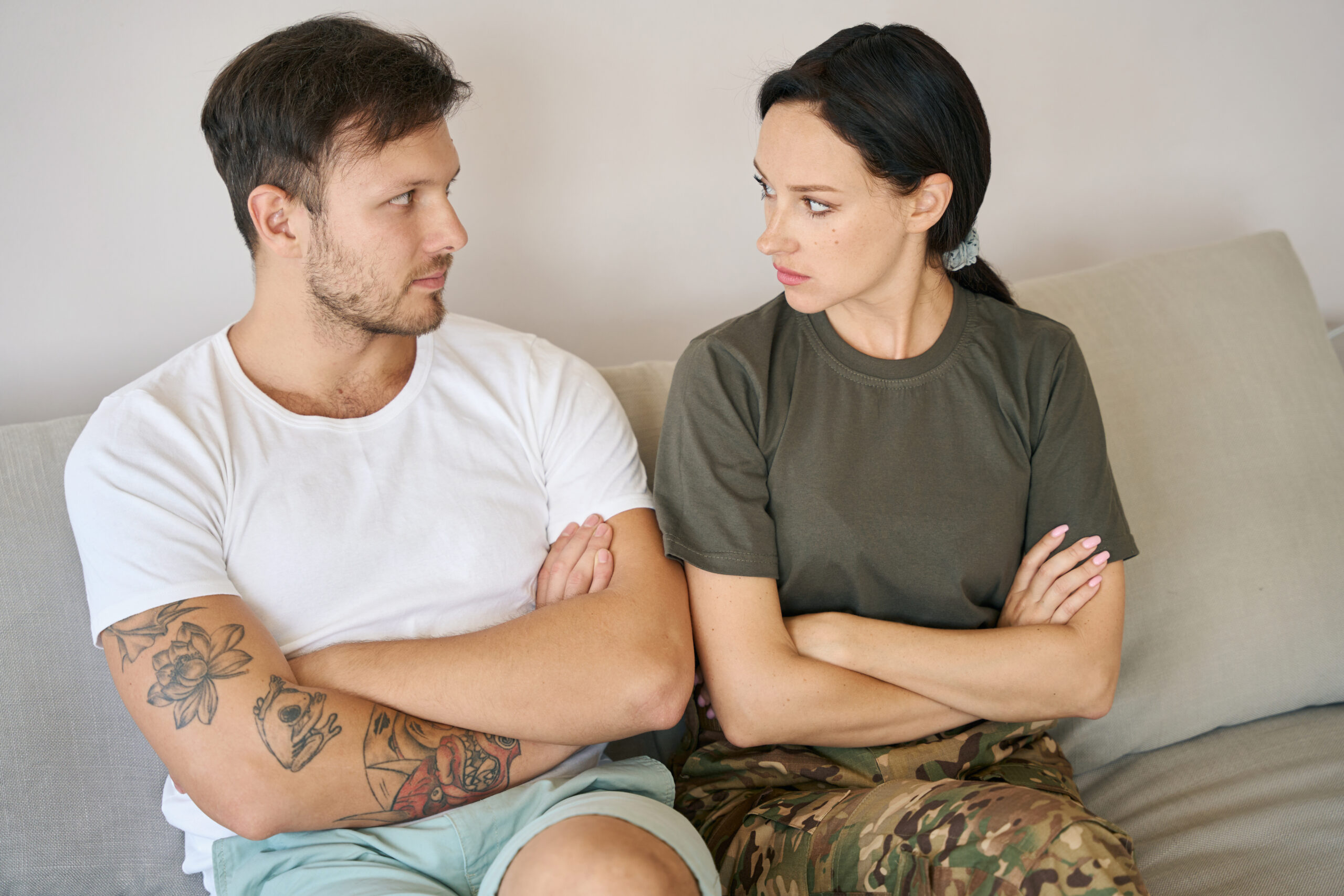 Man and woman sitting on sofa in closed poses