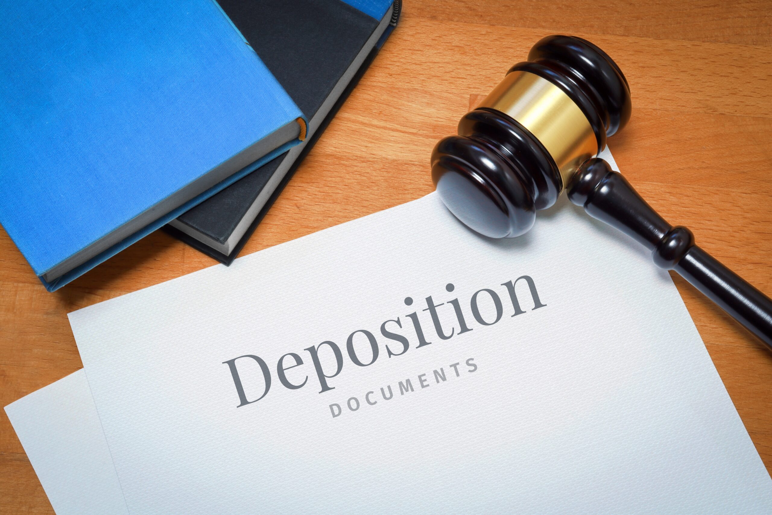 Deposition. Document with label. Desk with books and judges gavel in a lawyer's office.